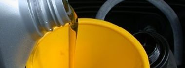 engine oil being poured into yellow funnel